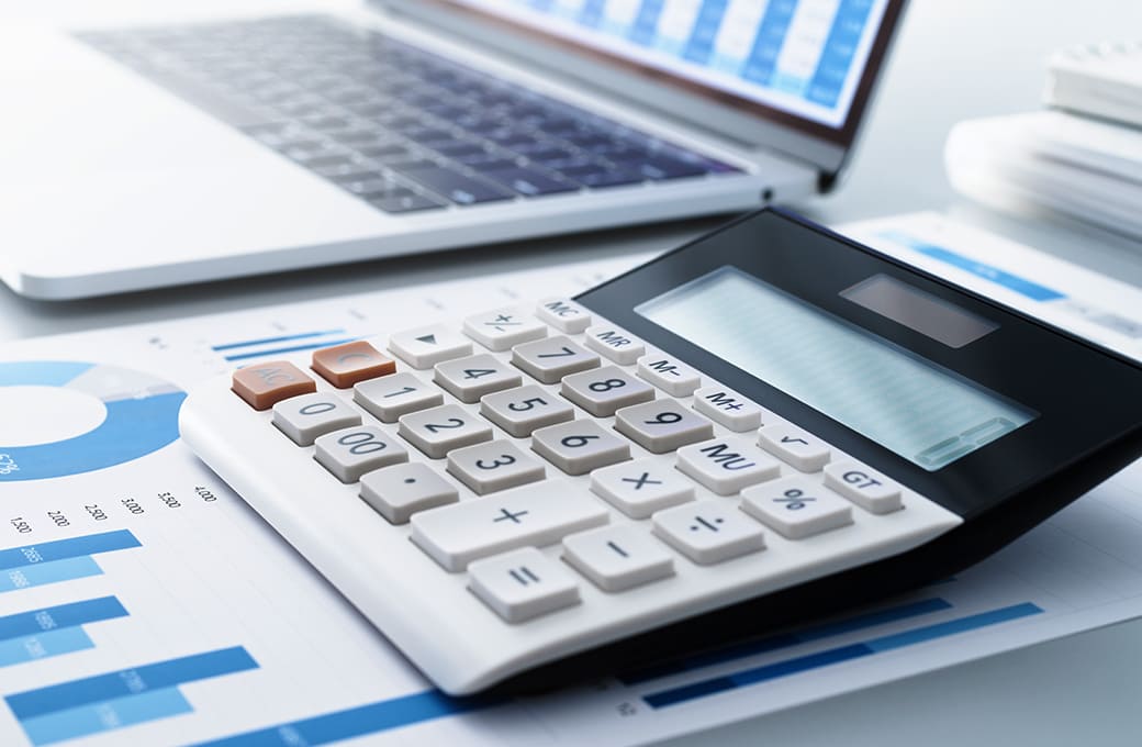 デスクの上にある電卓、資料、PC